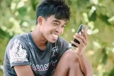 meme hài chàng trai ngồi xem điện thoại cười 1 mình